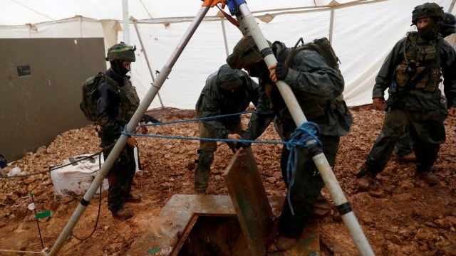 Sejumlah tentara Israel mengangkat tutup lubang gali perbatasan dari Lebanon sampai Israel  di sisi perbatasan Israel dekat kota Menula.  (Foto: REUTERS/ Ronen Zvulun)