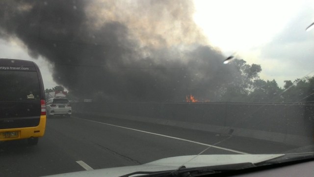 Sebuah bus terbakar di Tol Cikampek. (Foto: Twitter/@Dacil213)