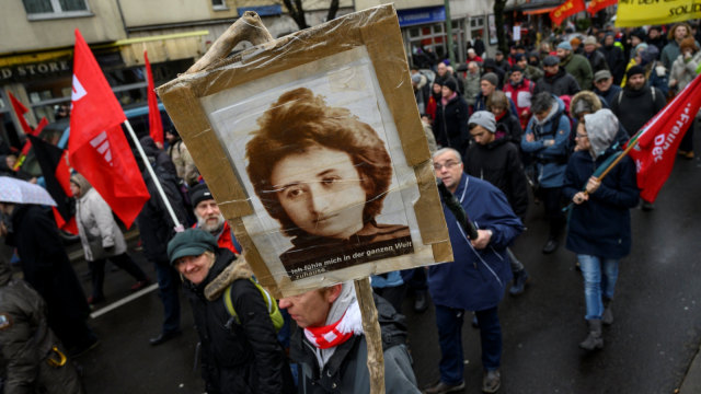 Seorang demonstran membawa poster Rosa Luxemburg saat 100 tahun kematiannya, Berlin, Jerman, Minggu (13/1/2019). (Foto: AFP/JOHN MACDOUGALL )