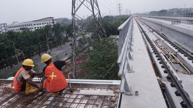 Sejumlah pekerja  proyek LRT Jabodebek merapihkan bagian  pembangunan Stasiun Taman Mini, Jakarta Timur, Senin (14/1). (Foto: Jamal Ramadhan/kumparan)