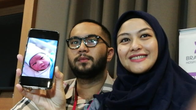 Revalina S. Temat dan suami, Rendy Aditya, memamerkan foto anak keduanya yang baru saja lahir. (Foto: Maria Gabrielle Putrinda/kumparan)