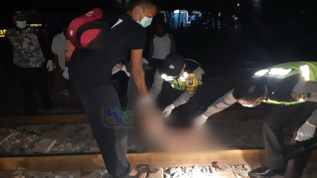Petugas saat melakukan evakuasi jenazah korban di jalur kereta api kilometer 150+8, Desa Blongsong Kecamatan Baureno Bojonegoro, Senin (14/01/2019).