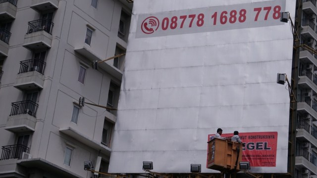 Petugas menyegel reklame di kawasan Jalan Gatot Soebroto, Jakarta, Senin (14/1). Foto: Jamal Ramadhan/kumparan