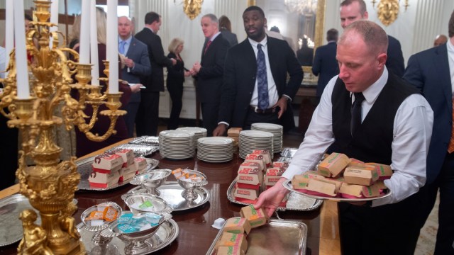 Para pelayanan Gedung Putih mengantarkan makanan cepat saji di Washington, Amerika Serikat. (Foto: AFP/SAUL LOEB)