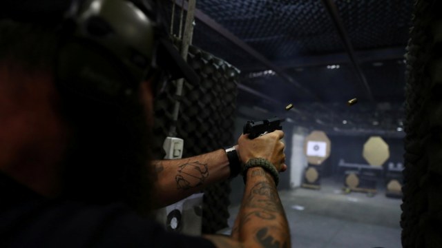 Pembeli mencoba senjata buatan Taurus Armas SA di Sao Leopoldo, Brasil. (Foto: REUTERS/Diego Vara)