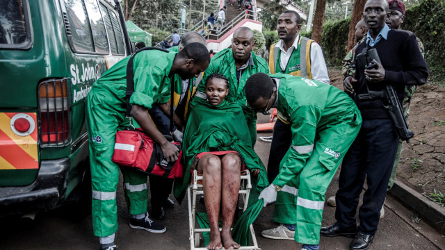 Seorang wanita dievakuasi dari tempat ledakan di komplek hotel di Westlands Nairobi (15/1/19). (Foto: AFP/Luis TATO )