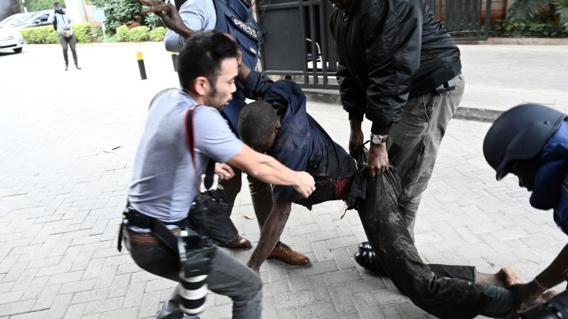 Sejumlah jurnalis evakuasi korban ledakan dan serangan teroris di Nairobi, Kenya  (15/1/19).  (Foto: AFP/SIMON MAINA )