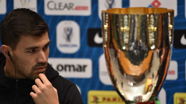 Kapten Milan Alessio Romagnoli memandangi trofi Supercoppa Italiana. (Foto: AFP/Fayez Nureldine)