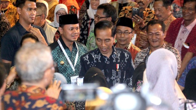 Presiden Joko Widodo (tengah) didampingi Wali Kota Bogor Bima Arya (kedua kiri) menghadiri acara Program Wirausaha ASN dan Pensiunan di SICC, Sentul, Bogor. Foto: ANTARA/Yulius Satria Wijaya