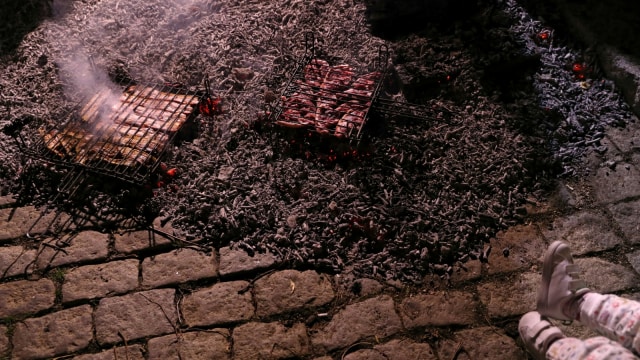 Masyarakat menggunakan sisa bara api perayaan tahunan "Luminarias" untuk memanggang aneka olahan daging. (Foto: REUTERS/Susana Vera)