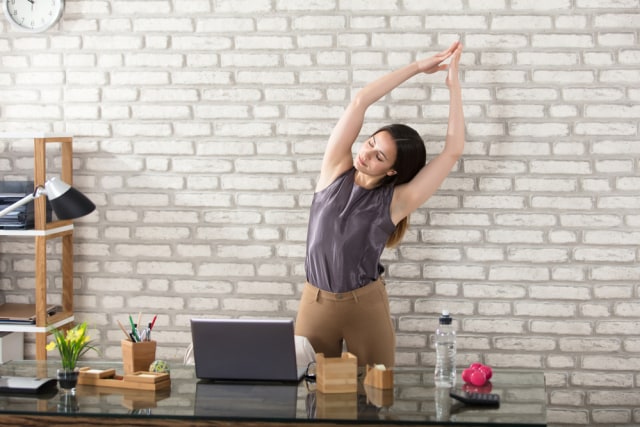 Melakukan peregangan di kantor. (Foto: Shutterstock)