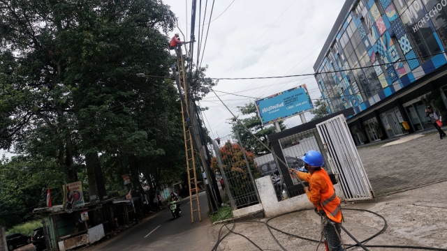 Pekerja sedang menarik kabel listrik dari jaringan listrik udara untuk ditanam ke bawah tanah. (Foto: Helmi Afandi Abdullah/kumparan)