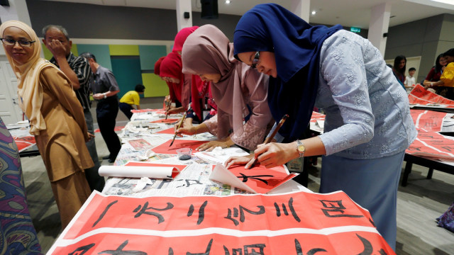 Sejumlah guru dari Malaysia ikut berpartisipasi dalam acara menulis Kaligrafi huruf Thiongkok untuk menyambut Tahun Baru Imlek di Tsun Jin High School di Kuala Lumpur, Malaysia. (Foto: REUTERS/Lai Seng Sin)