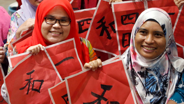 Sejumlah guru dari Malaysia ikut berpartisipasi dalam acara menulis Kaligrafi huruf Thiongkok untuk menyambut Tahun Baru Imlek di Tsun Jin High School di Kuala Lumpur, Malaysia. (Foto: REUTERS / Lai Seng Sin)