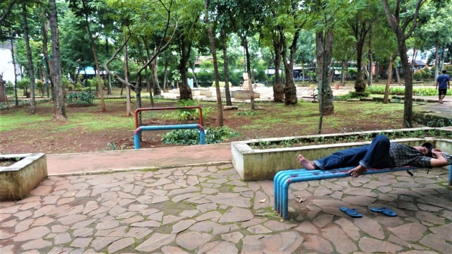 Seorang warga yang melintas di salah satu taman di Jakarta sedang beristirahat di fasilitas taman. (Foto: Helmi Afandi/kumparan)