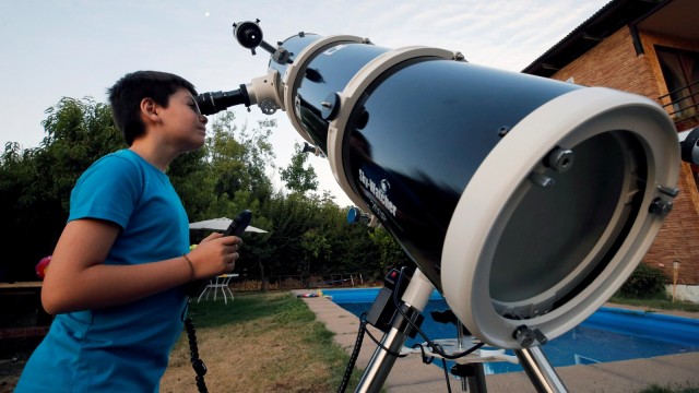 Ricardo Barriga, mengamati bulan dengan teleskopnya. (Foto: REUTERS/Rodrigo Garrido)