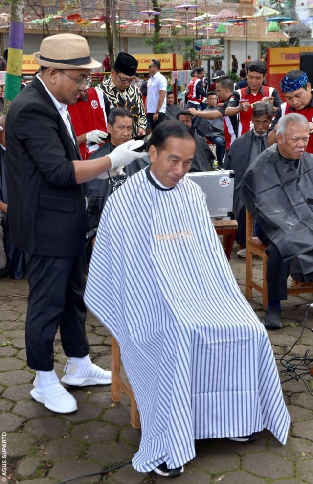 Presiden Joko Widodo saat dipangkas rambutnya oleh Herman, pemuda asal Garut. (Foto: Presidential Palace/Agus Suparto)