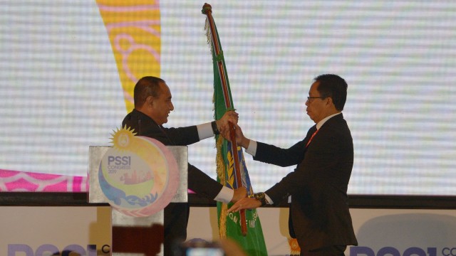 Ketua Umum PSSI Edy Rahmayadi (kiri) menyerahkan bendera organisasi sepak bola Indonesia kepada Wakil Ketua Umum PSSI Djoko Driyono seusai menyatakan pengunduran diri dalam pembukaan Kongres PSSI 2019 di Nusa Dua, Bali, Minggu (20/1/2019). (Foto: ANTARA FOTO/Nyoman Budhiana)