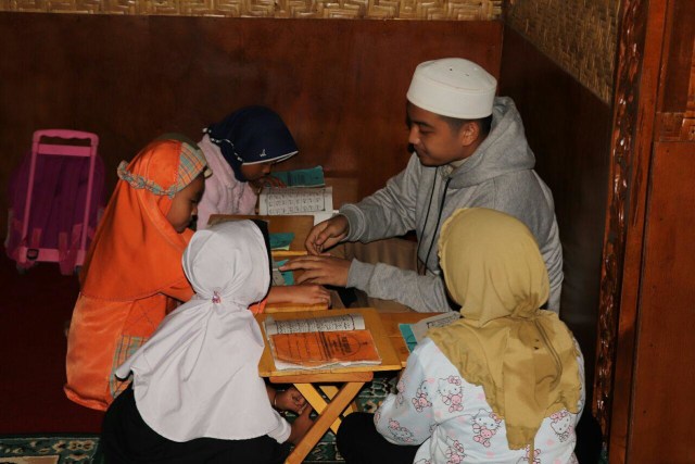 Dengan penuh kesabaran, santri Daarul Qur'an mengajar ngaji santri cilik Suku Tengger. (Foto: Gashendo/Daarul Qur'an)
