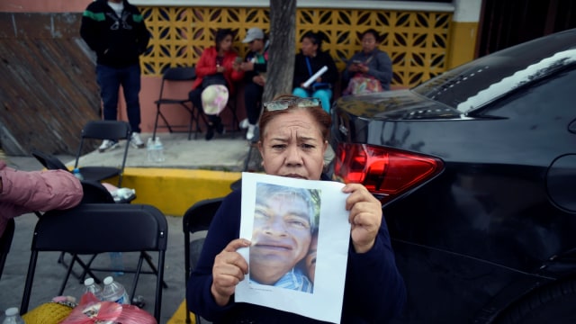 Seorang wanita menunjukan foto kerabatnya yang menjadi korban ledakan pipa minyak di Tlahuelilpan, Meksiko, (19/1/19).  (Foto: AFP/ALFREDO ESTRELLA)