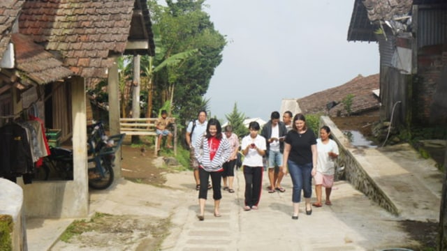 Sejumlah wisatawan menyusuri jalan Desa Kenalan di antara rumah-rumah warga yang tertata rapi. Foto: Dok. PT TWC (Persero)