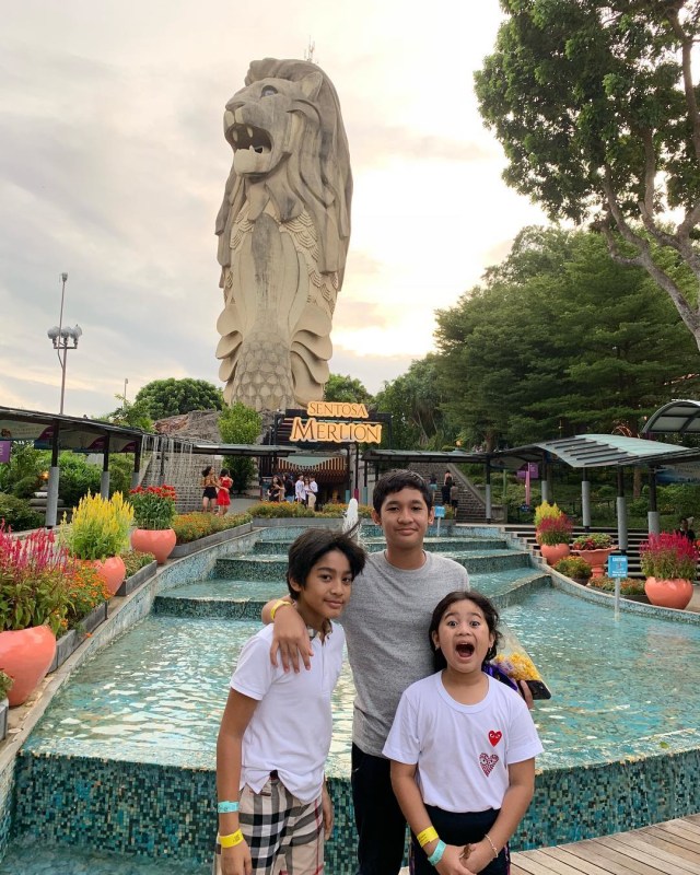 Ardio, Keny, dan Lova Taulany berbose di depan patung Sentosa Merlion di Sentosa Island. (Foto: Instagram @erintaulany)