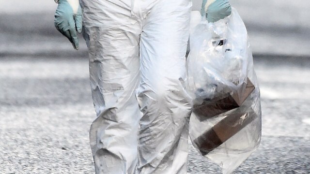 Petugas forensik membawa kantong plastik di dekat ledakan bom mobil di Londonderry, Irlandia, (20/1).  (Foto: REUTERS / Clodagh Kilcoyne)