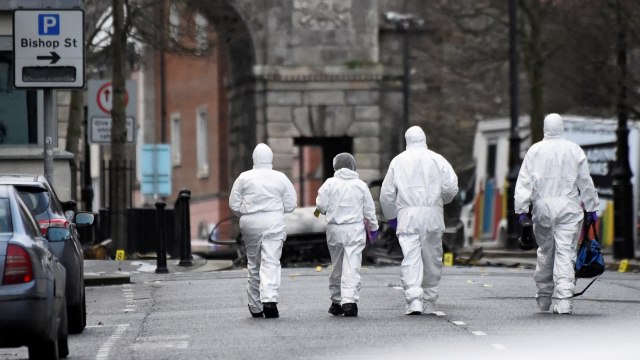 Sejumlah petugas forensik berjalan mendekati ledakan bom mobil di Londonderry, Irlandia, (20/1).  (Foto: REUTERS / Clodagh Kilcoyne)