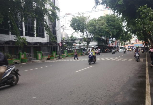 Pejalan kaki menyeberang di depan Masjid Noor, Jalan Pangeran Samudera atau kawasan Pasar Lima, Banjarmasin. (Foto: Zahidi/banjarhits.id)