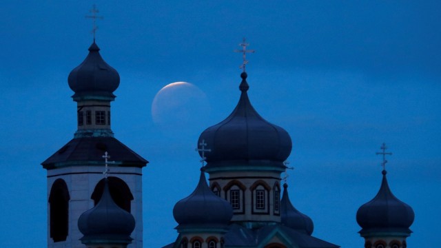 Fenomena 'super blood wolf moon' terlihat di belakang sebuah gereja Ortodoks selama gerhana bulan di desa Turets, Belarus, (21/1).  (Foto: REUTERS / Vasily Fedosenko)
