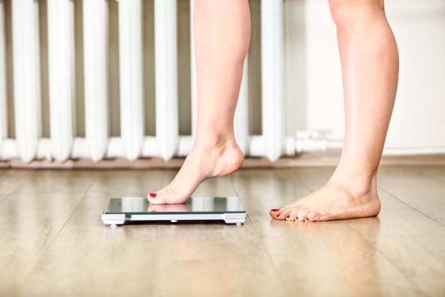 Perempuan Menimbang Berat Badan. Foto: Shutterstock
