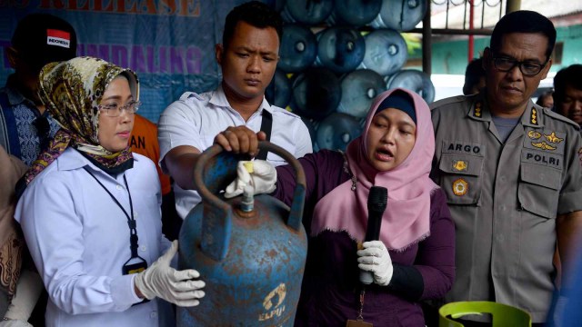 Kabid Humas Polda Metro Jaya Kombes Pol Argo Yuwono (kanan) didampingi Kasubdit III Sumdaling menunjukkan tabung gas saat rilis kasus pengoplosan LPG di Cipayung, Jakarta Timur, Selasa (22/1/2019). (Foto: ANTARA FOTO/Sigid Kurniawan)