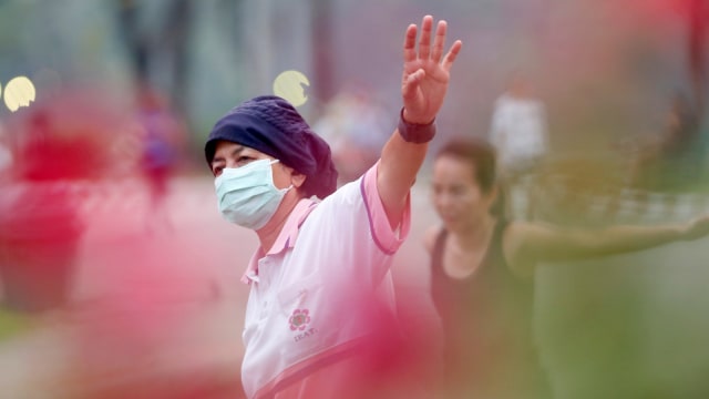 Seorang wanita memakai masker saat dia berolahraga di Bangkok, Thailand. (Foto: REUTERS/Soe Zeya Tun)