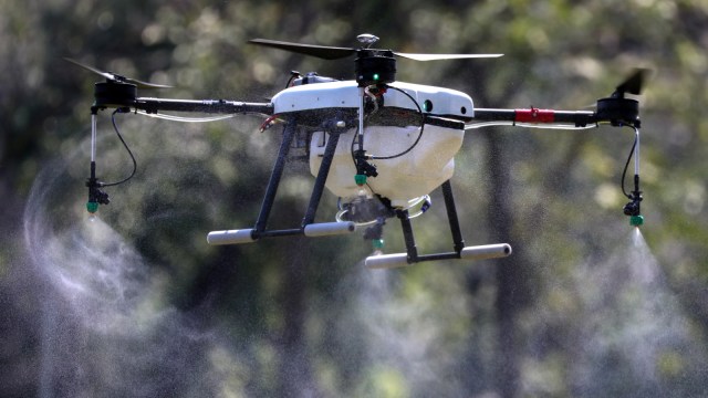 Drone yang  terbang dan menyemprotkan bahan kimia selama operasi untuk mengurangi polusi udara di Bangkok, Thailand, (22/1).  Foto: REUTERS/Athit Perawongmetha