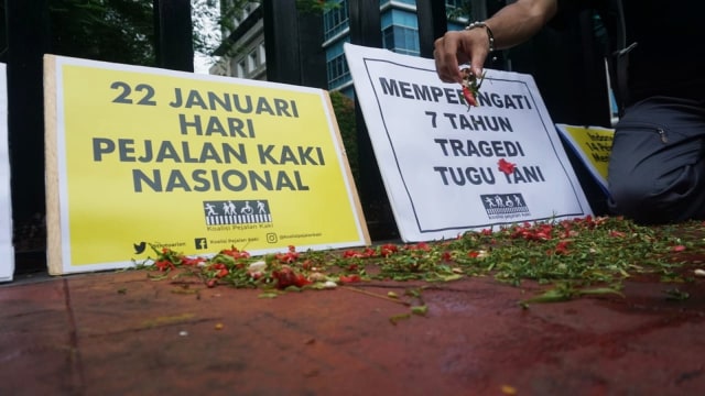 Sejumlah warga turut menabur bunga sebagai ungkapan belasungkawa atas tragedi kecelakaan tragis di Tugu Tani pada 7 taun silam, Jakarta (22/1).  (Foto: Iqbal Firdaus/kumparan )