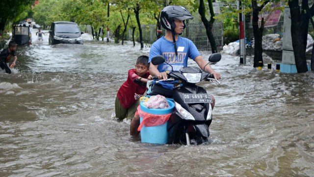 Pengendara melewati banjir di Jalan Pendidikan Makassar, Sulawesi Selatan, Selasa (22/01/2019).  (Foto: ANTARA FOTO/Sahrul Manda Tikupadang)