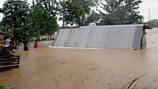 Warga berusaha menyelamatkan sebuah rumah yang akan terbawa arus aliran sungai Jeneberang yang meluap di Kabupaten Gowa, Sulawesi Selatan, Selasa (22/1/2019).  (Foto: ANTARA FOTO/Abriawan Abhe)