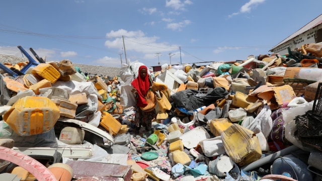 Seorang wanita mencari sampah plastik di tempat sampah untuk didaur ulang menjadi genteng di pabrik daur ulang Envirogreen di Mogadishu, Somalia. (Foto: REUTERS/Feisal Omar)