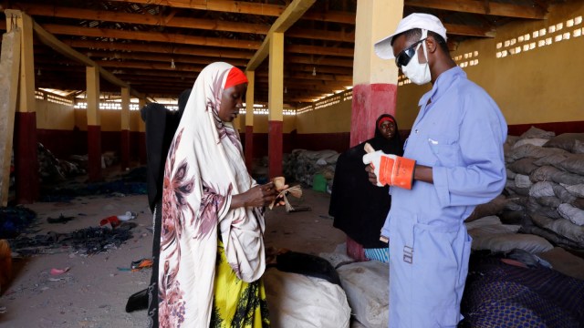 Seorang wanita mendapatkan bayaran dari sampah plastik yang dibawanya ke pabrik daur ulang Envirogreen di Mogadishu, Somalia.  (Foto: REUTERS/Feisal Omar)