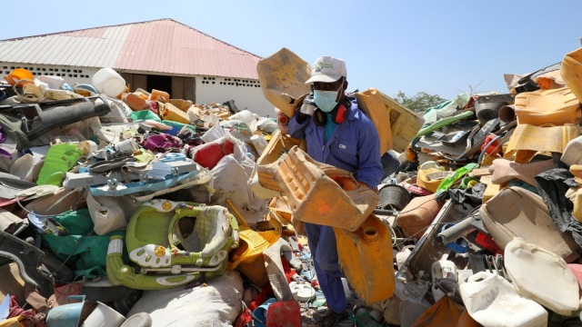 Seorang lelaki memilah sampah plastik yang dikumpulkan dari tempat sampah untuk didaur ulang menjadi genteng di pabrik daur ulang Envirogreen di Mogadishu, Somalia. (Foto: REUTERS/Feisal Omar)