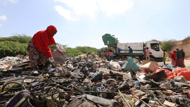 Seorang wanita mencari sampah plastik di tempat sampah untuk didaur ulang menjadi genteng di pabrik daur ulang Envirogreen di Mogadishu, Somalia. (Foto: REUTERS/Feisal Omar)