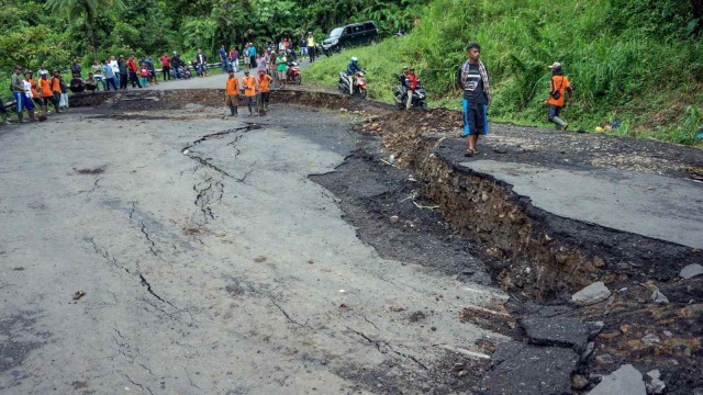 Sejumlah warga melihat jalan yang ambles di Desa Tenogo, Paninggaran, Kabupaten Pekalongan, Jawa Tengah, Rabu (23/1/2019). (Foto:  ANTARA FOTO/Harviyan Perdana Putra/wsj.)