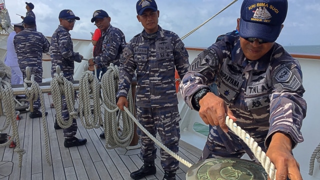 Petugas sedang menarik tali layar untung mengembangkan layar. (Foto:  Fachrul Irwinsyah/kumparan)