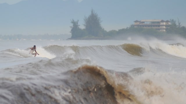 Peselancar memanfaatkan gelombang tinggi di pantai Padang, Sumatera Barat, Selasa (22/1).  (Foto: ANTARA FOTO/Iggoy el Fitra)