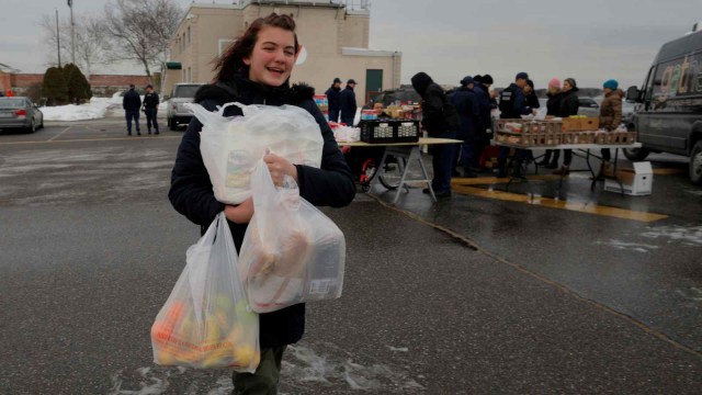 Seorang anak penjaga pantai di Amerika Serikat membantu ibunya membawakan makanan. (Foto: REUTERS/Brian Snyder)