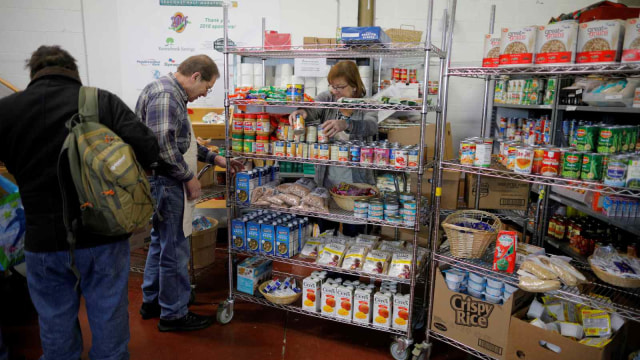 Para relawan menyimpan makanan di rak-raknya untuk diberikan kepada Pegawai Negeri Sipil yang tidak dibayar akibat penutupan pemerintahan Amerika Serikat. (Foto: REUTERS/Brian Snyder)