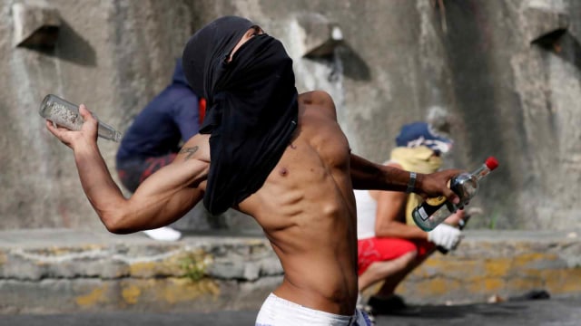 Seorang demonstran bentrok dengan pasukan kemananan Venezuela, Caracas, Venezuela (21/1/2019).  (Foto: REUTERS/Carlos Garcia Rawlins)