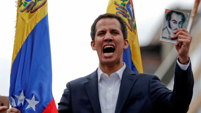 Juan Guaido, Plt Presiden Venezuela, memegang salinan konstitusi Venezuela, Caracas, Venezuela (23/1/2019). (Foto: REUTERS/Carlos Garcia Rawlins)