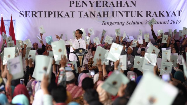 Presiden Joko Widodo menghitung sertifikat tanah saat penyerahan di halaman Skadron 21/Sena Puspenerbad Pondok Cabe Ilir, Tangerang Selatan, Banten, Jumat (25/1). Foto: Antara/Puspa Perwitasari