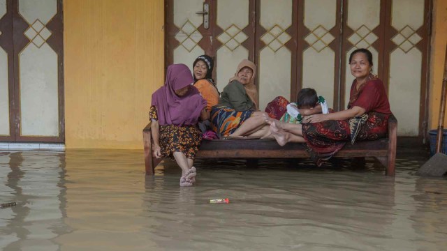 Sejumlah warga duduk di atas kursi di lokasi terdampak banjir, di Pekalongan, Jawa Tengah, Minggu (27/1/2019).  (Foto: ANTARA FOTO/Harviyan Perdana Putra)